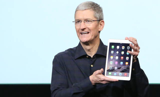 Apple CEO Tim Cook holds an iPad during a presentation at Apple headquarters in Cupertino